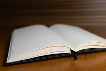 Open blank notebook with lined pages resting on wooden surface, inviting creativity and ideas for writing or sketching purposes. Negative space