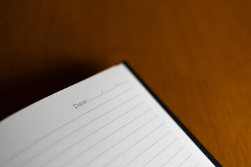 Blank notebook page with lined paper and wooden table background, inviting creativity and organization for personal notes and reflections. Negative space