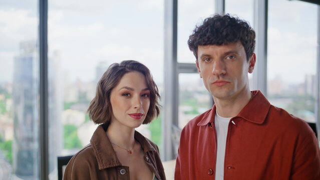 Two creative specialists posing in panoramic window portrait. Colleagues couple