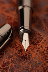 Fountain pen, beautiful fountain pen on rustic leather surface, selective focus.