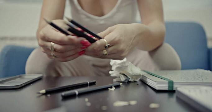 Experience the soothing sounds as a young woman with red nails meticulously sharpens pencils and neatly places them into a metallic pencil case. This video creates a relaxing ASMR experience.