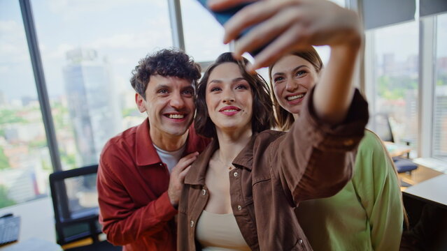 Corporate team making selfie standing modern office laughing together closeup