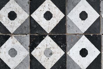 Black and white geometric tile floor worn pattern design