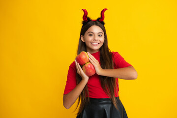 Child teen girl having fun on Halloween. Funny little girl with pumpkin isolated on yellow. Halloween witch girl. Cute teen witch. Happy Halloween. Portrait of an Halloween child.