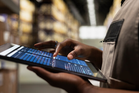 Close up of industrial operations worker verifying parcel shipment details on tablet, order processing for cargo and inventory management. Transportation records for daily activities.