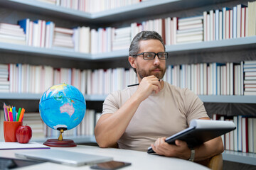 Teacher in classroom. Knowledge and education with handsome teacher. Teacher with book in classroom. Man on lesson in class. Teachers from university exam. College teacher. Teaching in university.