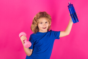 Sporty kids, studio isolated portrait on pink red background. Child boy working out with dumbbells. Kids sport and active healthy life. Sport and kids training.