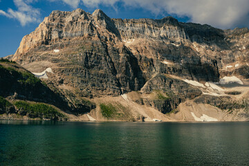 Mountain lake scene featuring a rugged cliff face
