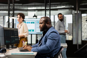 Black manager uses digital technology to forecast business performance in a multinational company...