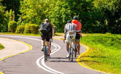 Obraz premium Cyclists ride on the bike path in the city Park 