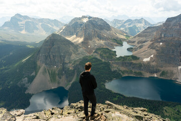 Scenic mountain view: a man gazes upon a landscape of lakes