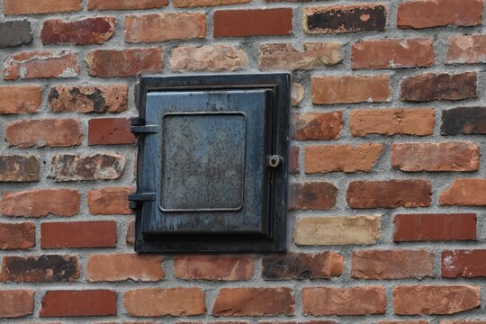 old brick wall with fireplace clean-out door