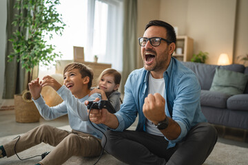 Father and kids having fun playing video games