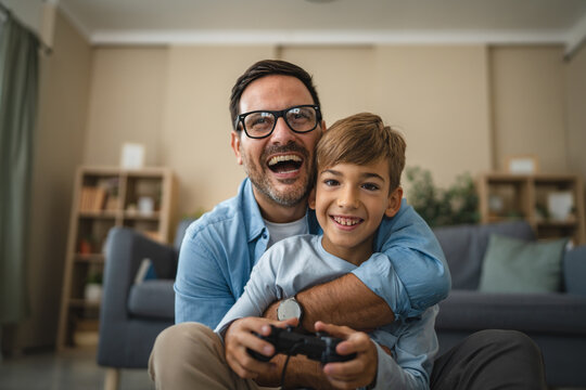 Happy father and son bonding while playing video game - Powered by Adobe