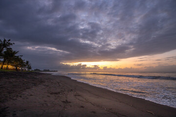 The sky is cloudy and the sun is setting