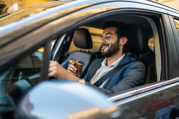 Man driving car and drinking from flask