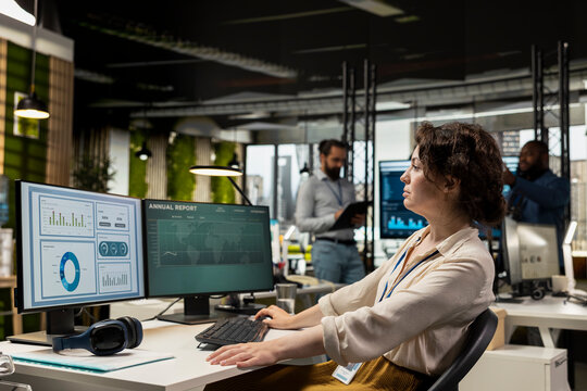 Fototapeta Woman employee focused on IT company development with digital tools, review analytics and performance metrics at workstation. Staff planning solutions and aligning objectives.