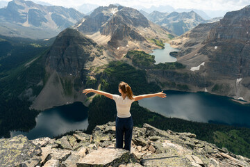 Woman embraces the panoramic scenery with arms outstretched.