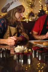 Chef In Hat And Apron Baking Cookies In Festive Kitchen With Christmas Lights
