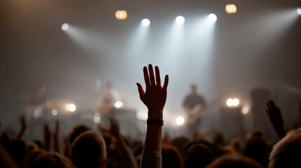 Energetic concert experience with band performing in spotlight from audience perspective