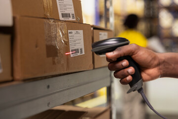 Close up of black worker scanning the barcode awb tags on cargo boxes, registering the merchandise...