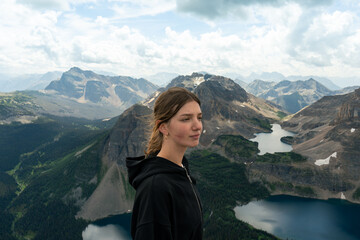 Naklejka premium Person enjoying mountain view, dressed in black on a sunny day