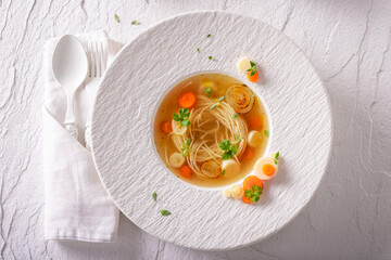 Exquisite broth soup decorated with coriander, carrot and parsley.