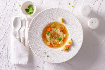 Exclusive broth soup with high-end presentation on plate.