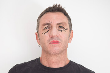 Fototapeta premium Portrait of forty-year-old man with eyes and mouth made up for Halloween. The man is forty years old and of Caucasian origin