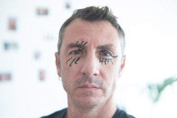 Man with face made up for Halloween. The man is forty years old and of Caucasian origin