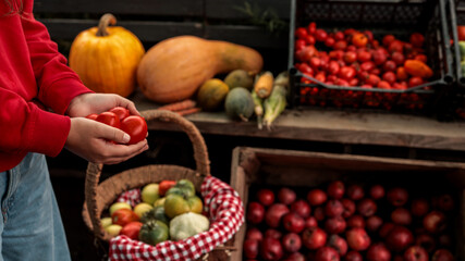 Person holding fresh tomatoes at a farmer's market