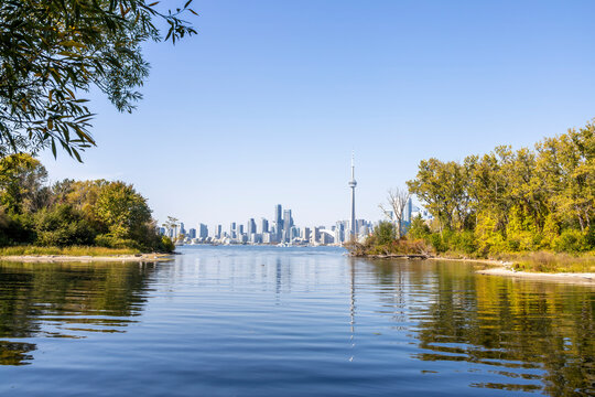 Stunning view of the Toronto skyline from Sunfish Cut on Ward's Island, showcasing the iconic CN Tower and Lake Ontario's serene waters.