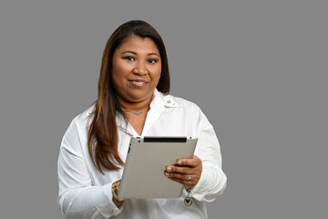 Woman using tablet smiles looking at camera