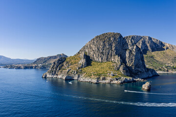 Capo Zafferano Italian coastal promontory and lighthouse aerial drone view by the Tyrrhenian Sea in Bagheria, Sicily Italy with rugged cliffs lush Mediterranean flora crystal clear water