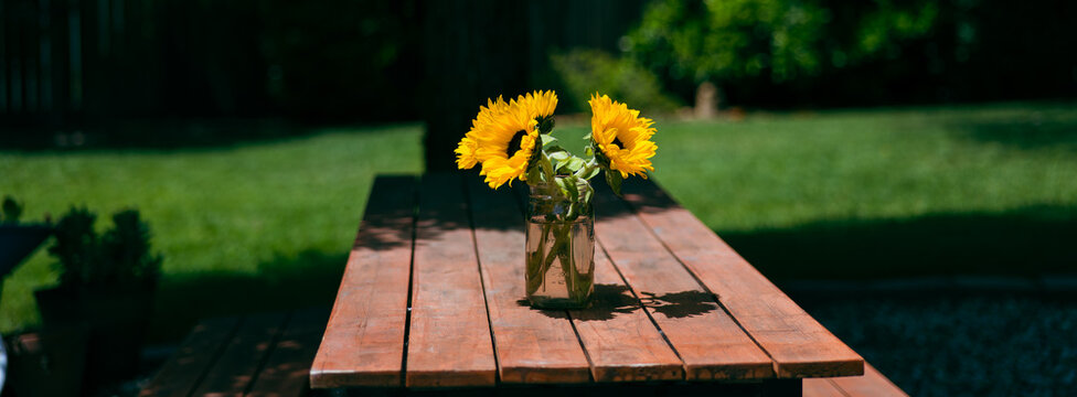 Bright Sunflowers in a Jar on a Rustic Wooden Garden Table
