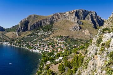Capo Zafferano Italian coastal promontory and lighthouse aerial drone view by the Tyrrhenian Sea in Bagheria, Sicily Italy with rugged cliffs lush Mediterranean flora crystal clear water