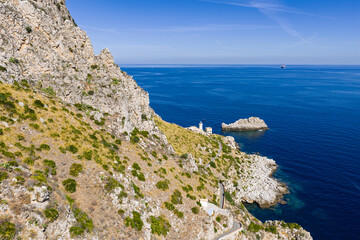 Capo Zafferano Italian coastal promontory and lighthouse aerial drone view by the Tyrrhenian Sea in Bagheria, Sicily Italy with rugged cliffs lush Mediterranean flora crystal clear water
