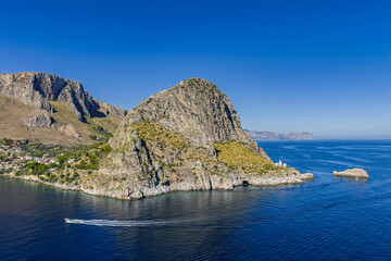 Capo Zafferano Italian coastal promontory and lighthouse aerial drone view by the Tyrrhenian Sea in Bagheria, Sicily Italy with rugged cliffs lush Mediterranean flora crystal clear water