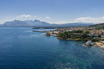 Obraz premium Sant Elia bay beach in Porticello town, Santa Flavia, Sicily, Italy, aerial drone view of Sicilian turquoise waters, rocky cliffs, colorful houses, and Mediterranean coastline panorama in Bagheria