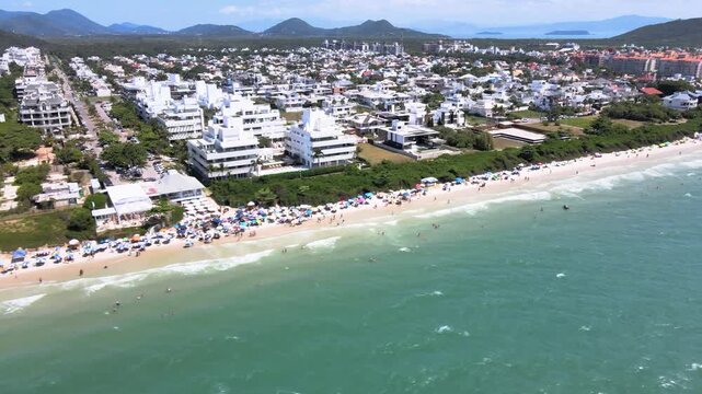 Panoramic aerial view of Jurere Internacional beach in Florian&oacute;polis, Santa Catarina, luxury homes, beach clubs, high-end residences on the seafront on a luxurious tourist beach sand crowded people.
