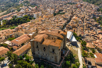 Obraz premium Aerial drone view of Castelbuono medieval town in the Madonie Mountains, Sicily, Italy, basking under the summer sun with historic streets, Ventimiglia Castle. Old mountain town in Sicily