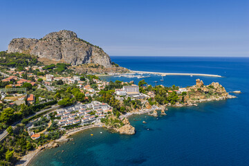 Obraz premium Aerial drone view of Scalette Beach in Cefalu, Sicily, Italy. the Tyrrhenian Sea, Capo Cefalu Lighthouse, rocky cliffs, Cefalu Harbor, and medieval castle ruins with scenic coastline panorama