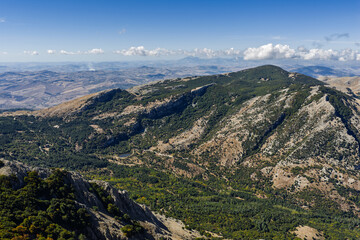 Aerial drone view of Mount Carbonara in the Madonie Mountains of Sicily, Italy. It reveals rugged limestone ridges, alpine meadows, and the Tyrrhenian Sea. Battaglia Pass, Sicily