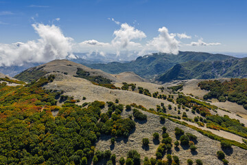 Aerial drone view of Mount Carbonara in the Madonie Mountains of Sicily, Italy. It reveals rugged limestone ridges, alpine meadows, and the Tyrrhenian Sea. Battaglia Pass, Sicily
