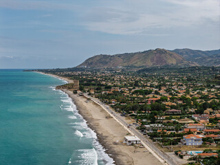 Fototapeta premium Aerial drone view of Campofelice di Roccella, a charming Sicilian seaside town in northern Sicily, Italy, showing traditional holiday homes, coastline, and panoramic Tyrrhenian Sea vistas