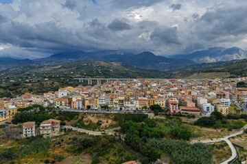 Obraz premium Aerial drone view of Campofelice di Roccella, a historic Sicilian village in Palermo,Sicily, Italy, featuring traditional stone houses, the Madonie Mountains, and the iconic highway viaduct