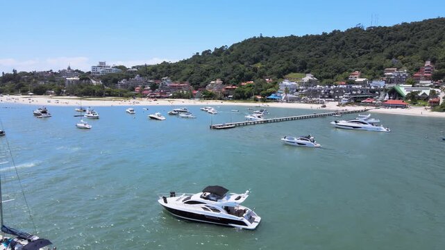 Aerial view of Jurer&ecirc; International, Traditional and Canajur&ecirc; beach in Florian&oacute;polis Santa Catarina with boats, yachts and sailboats in the turquoise blue sea with marina and pier.

