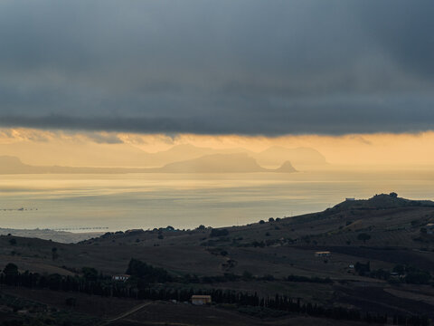 Aerial drone view of Capo Zafferano, a scenic Sicilian coastal promontory in the Metropolitan City of Palermo, Italy, featuring distant views of the Tyrrhenian Sea and the majestic Madonie Mountains