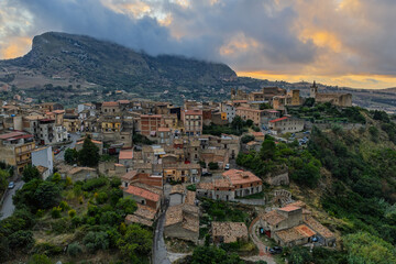 Obraz premium Aerial drone view of Collesano Sicilian mountain town at sunset with Basilica San Pietro church and historic stone streets in the Madonie Mountains, Sicily, Italy. Old mountain town in Sicily