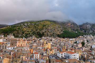 Fototapeta premium Aerial drone view of Collesano Sicilian mountain town at sunset with Basilica San Pietro church and historic stone streets in the Madonie Mountains, Sicily, Italy. Old mountain town in Sicily